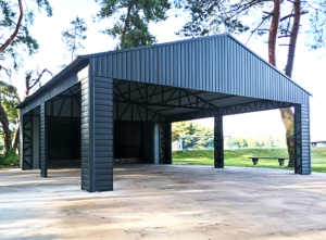 7x7m DELUX carport / tractor shed with gable roof, skirting, horizontal sheeting on the posts and vertical sheeting under the roof, double painted (black) frame structure