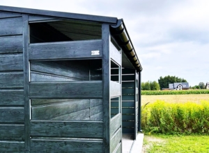 5x5m DELUX storage, with gable roof, 1m wide open part on the right side, with gap plating, double wing door, with edging, gutter, wide horizontal plating, galvanized frame structure