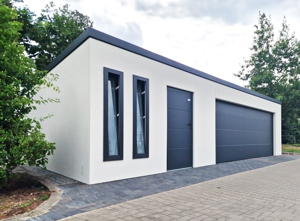 9,5x6,29m DELUX plastered insulated mobile garage with sloping roof, sectional door, 2 doors, 2 windows, partition and separate storage room, guttering, PIR sandwich panel wall and roof construction