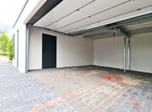 9,5x6,29m DELUX plastered insulated mobile garage with sloping roof, sectional door, 2 doors, 2 windows, partition and separate storage room, guttering, PIR sandwich panel wall and roof construction
