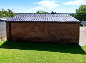 6x7m-es minőségi mobilgarázs, nyeregtetővel, cserepeslemezzel és filcborítással, világos aranytölgy falakkal, billenőkapuval és ajtóval, csokoládébarna tetővel, ablakkal, szegélyekkel, ereszcsatornával, vízszintes lemezeléssel, dupla festékréteggel kezelt (fekete) vázszerkezettel
