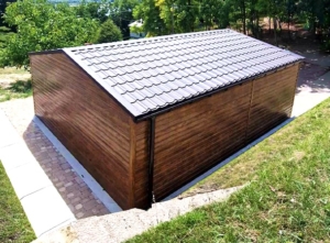 6x7m-es minőségi mobilgarázs, nyeregtetővel, cserepeslemezzel és filcborítással, világos aranytölgy falakkal, billenőkapuval és ajtóval, csokoládébarna tetővel, ablakkal, szegélyekkel, ereszcsatornával, vízszintes lemezeléssel, dupla festékréteggel kezelt (fekete) vázszerkezettel