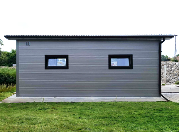 PULION DELUX minőségi szendvicspanel garázs YUKON 6,3x5,3m-es DELUX szigetelt mobilgarázs hátra lejtő tetővel, szekcionált kapuval, ajtóval, ablakokkal, szegélyekkel, ereszcsatornával, horganyzott vázszerkezettel