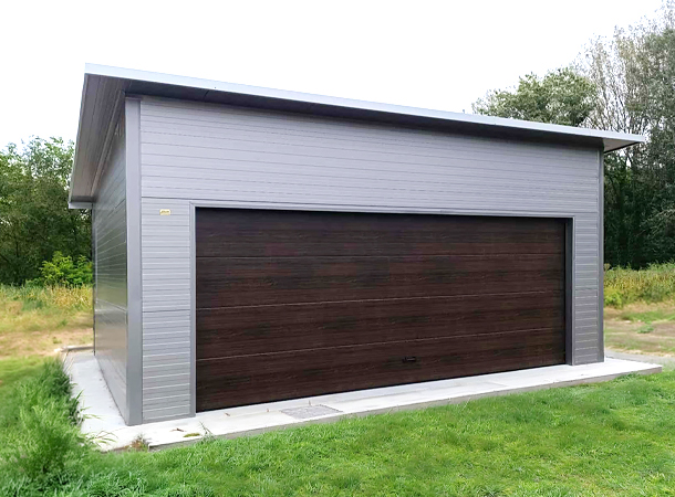6,3x5,3m-es DELUX szigetelt mobilgarázs hátra lejtő tetővel, szekcionált kapuval, ajtóval, ablakokkal, szegélyekkel, ereszcsatornával, horganyzott vázszerkezettel