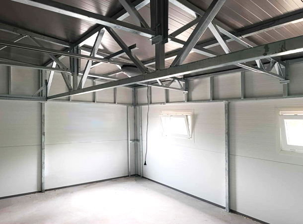 PULION DELUX minőségi szendvicspanel garázs YUKON 6,3x5,3m-es DELUX szigetelt mobilgarázs hátra lejtő tetővel, szekcionált kapuval, ajtóval, ablakokkal, szegélyekkel, ereszcsatornával, horganyzott vázszerkezettel