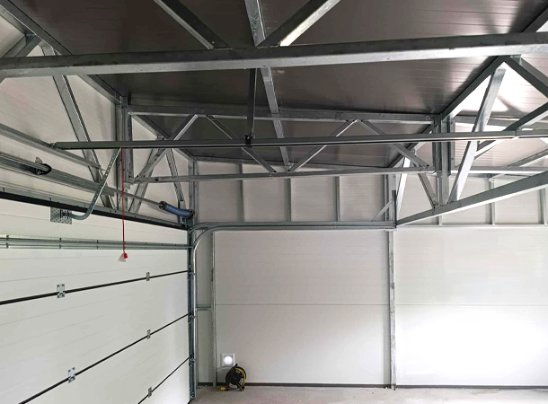 PULION DELUX minőségi szendvicspanel garázs YUKON 6,3x5,3m-es DELUX szigetelt mobilgarázs hátra lejtő tetővel, szekcionált kapuval, ajtóval, ablakokkal, szegélyekkel, ereszcsatornával, horganyzott vázszerkezettel