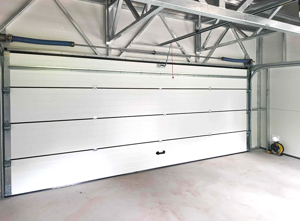 PULION DELUX minőségi szendvicspanel garázs YUKON 6,3x5,3m-es DELUX szigetelt mobilgarázs hátra lejtő tetővel, szekcionált kapuval, ajtóval, ablakokkal, szegélyekkel, ereszcsatornával, horganyzott vázszerkezettel