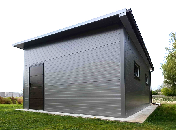 PULION DELUX minőségi szendvicspanel garázs YUKON 6,3x5,3m-es DELUX szigetelt mobilgarázs hátra lejtő tetővel, szekcionált kapuval, ajtóval, ablakokkal, szegélyekkel, ereszcsatornával, horganyzott vázszerkezettel